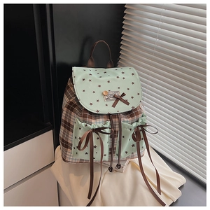 Detail of plaid canvas backpack with mint green ruffles and oversized bow ribbons
