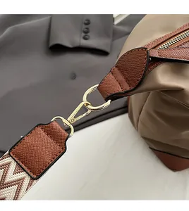 Detail of durable gold-tone metal hooks and reinforced leather trim on oxford tote bag