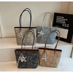 Close-up of printed tote bags in four colors with floral patterns and star charms