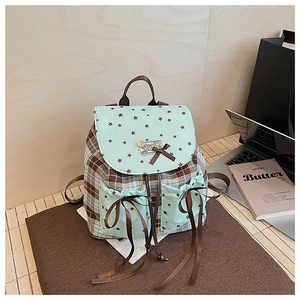 Detailed view of a plaid backpack with mint green accents in a cozy study setting