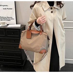 Detail of nylon tote bag with leather handles and geometric crossbody strap on model