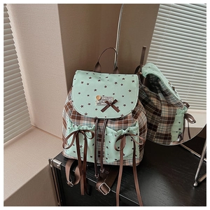 Detail of checkered college style backpack showing mint green prints and ribbon bow pockets