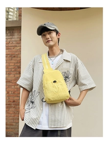 Adjustable yellow nylon chest bag with drawstring pocket shown on a male model outdoors