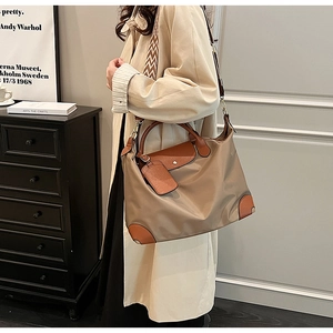 Detail of khaki nylon tote bag with leather trim and geometric patterned shoulder strap