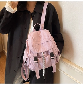 Detalle de mochila lavanda con cordón y cierre de doble hebilla llevada por modelo