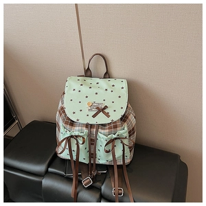 Detail shot of the checkered backpack featuring mint star prints and brown bow accents