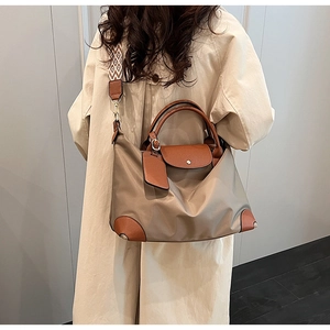 Detail of khaki nylon tote bag with brown leather handles and jacquard wide shoulder strap