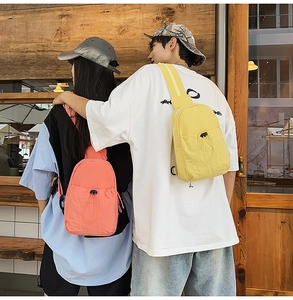 Detail of lightweight nylon backpacks in yellow and pink with drawstring pockets and texture
