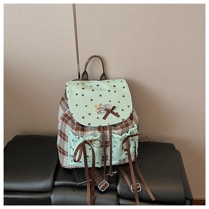 Detail of plaid backpack with mint green flap, star prints, and cute brown bow decoration