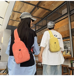 Detail of adjustable drawstring pocket on stylish nylon sling bag in vibrant colors
