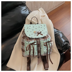 Close-up of academic style backpack with blue plaid fabric and star pattern details
