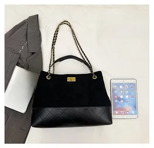 Detail view of large quilted suede tote bag with golden metal chain strap and twist-lock