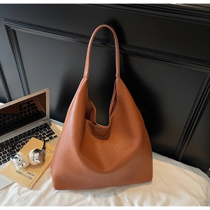 Close-up of caramel pebbled leather tote bag with a minimalist large capacity design