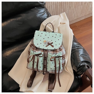 Detail of plaid backpack with mint green star pockets and bow knot on leather seat