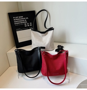 Tre borse tote minimaliste in tela nei colori bianco, nero e rosso in un set moderno