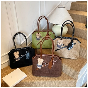 Detailed shot of four colorful suede tote bags with cute bear pendants on steps