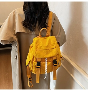 Detalle de mochila de nailon amarillo vibrante con cierre de hebilla de plástico negro