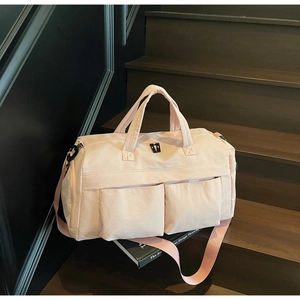 Close-up of pink travel bag with dual handles and adjustable strap on stairs