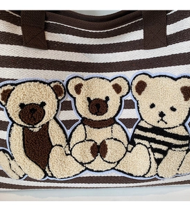 Détail du sac en toile rayé avec trois oursons en broderie bouclée en relief