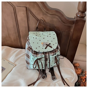 Detail of plaid backpack with mint green star flaps and brown ribbon bows
