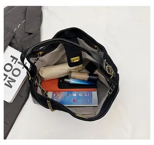 Spacious interior of a black chain bucket bag showing storage for phone and cosmetics