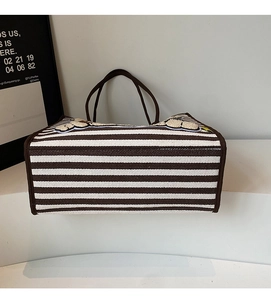Détail d'un sac cabas en toile à rayures marron avec des décorations en peluche