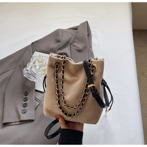 Détail du sac seau en daim beige avec chaîne dorée et marquage Fashion & Bag