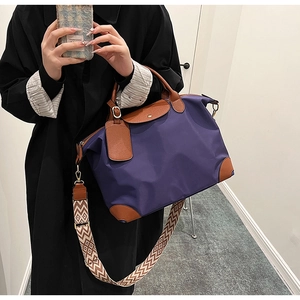 Detail of purple nylon tote bag with brown leather handles and wavy pattern shoulder strap