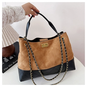 Detail of suede and leather tote bag featuring diamond stitching and gold turn-lock