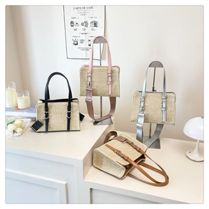 Detail of four woven straw handbags in black pink silver and brown with leather straps