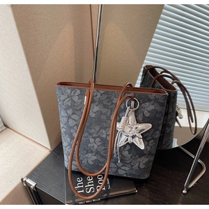 Detailed macro view of the butterfly print tote bag with premium silver starfish charm