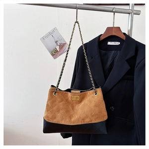 Detail of vintage suede tote bag with diamond quilting and golden rotary lock