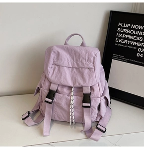 Detail view of the light purple nylon backpack featuring functional black buckle straps