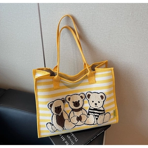 Détail du sac cabas en toile rayé jaune avec trois ours en peluche brodés sur le devant