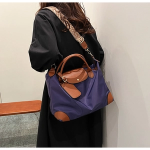 Detail of purple nylon tote with brown leather handles and wide geometric shoulder strap