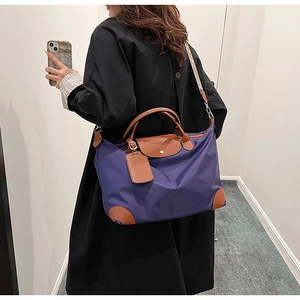 Detail of purple nylon tote bag with brown leather trim and jacquard shoulder strap