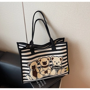Gros plan du sac cabas en toile rayé avec des broderies d'oursons en peluche 3D en relief