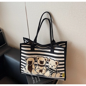 Détail du sac cabas rayé en toile avec trois écussons oursons floqués et poignées noires
