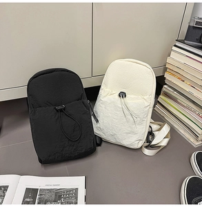 Close-up of minimalist nylon shoulder bags in black and beige with stylish pleated texture