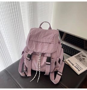 Detail view of the lavender nylon backpack showing double buckle flap and drawstring detail
