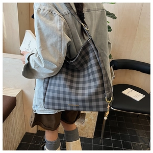 Dettaglio della borsa tote a scacchi con ciondolo di perle e logo in stile lifestyle