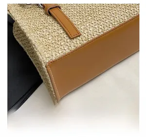 Close-up of precise stitching on woven straw tote bag with brown leather accents