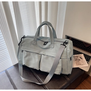 Detail of light blue waterproof travel bag with double handles and adjustable strap