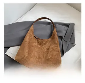 Detail of vintage brown suede tote bag with clean stitching and minimalist shoulder strap
