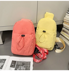 Detail of coral orange and bright yellow nylon crossbody bags with drawstring pocket