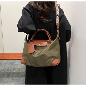 Detail of olive nylon tote with brown leather trim and patterned crossbody strap