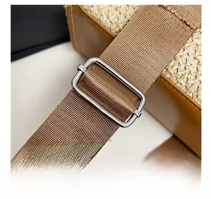 Detail of adjustable nylon shoulder strap with silver buckle on woven beach bag