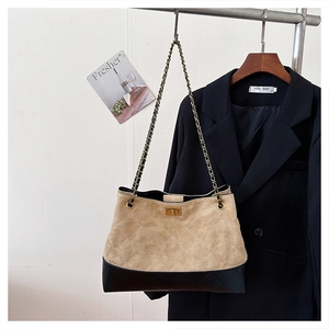 Detail of vintage beige suede tote bag with chain strap and gold turn-lock closure