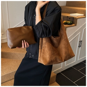 Detailed view of brown matte tote bag and matching clutch set on a model