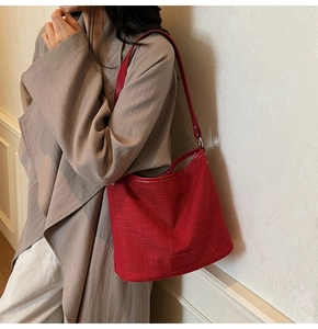 Dettaglio della trama in tessuto rosso intrecciato e bordo in pelle sulla borsa a tracolla